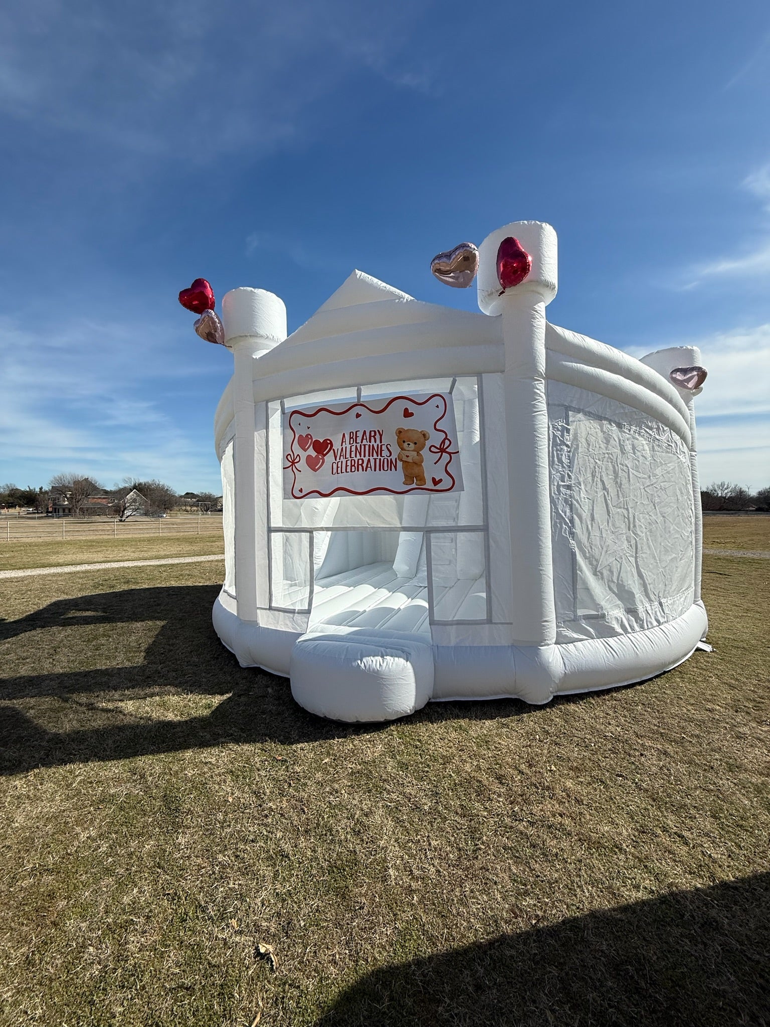 Modern minimalist white bounce house "The Opal" featuring dual inflatable slides and mesh netting for visible play - DFW Confetti Bounce